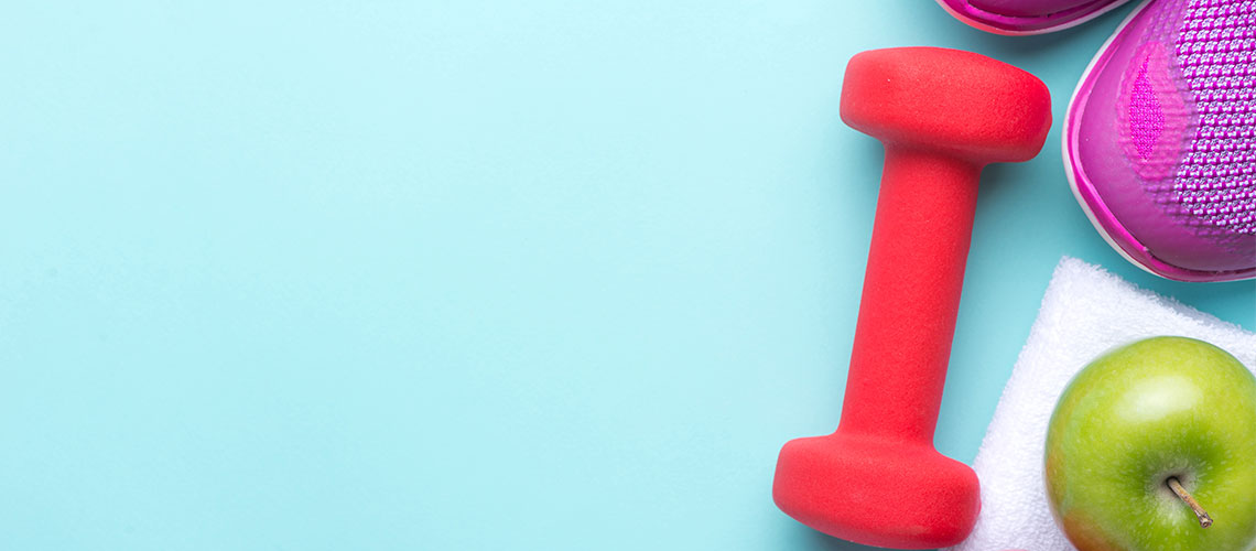 a red weight next to an apple and shoes